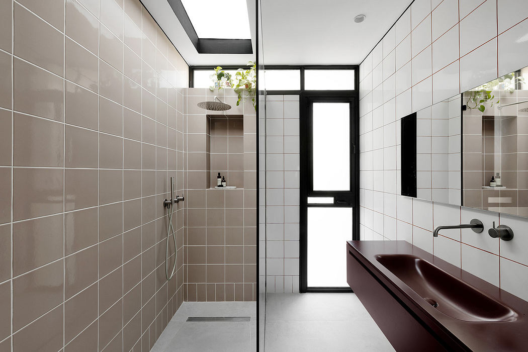 Modern bathroom with beige tiles, black accents, and a glass shower cabin.