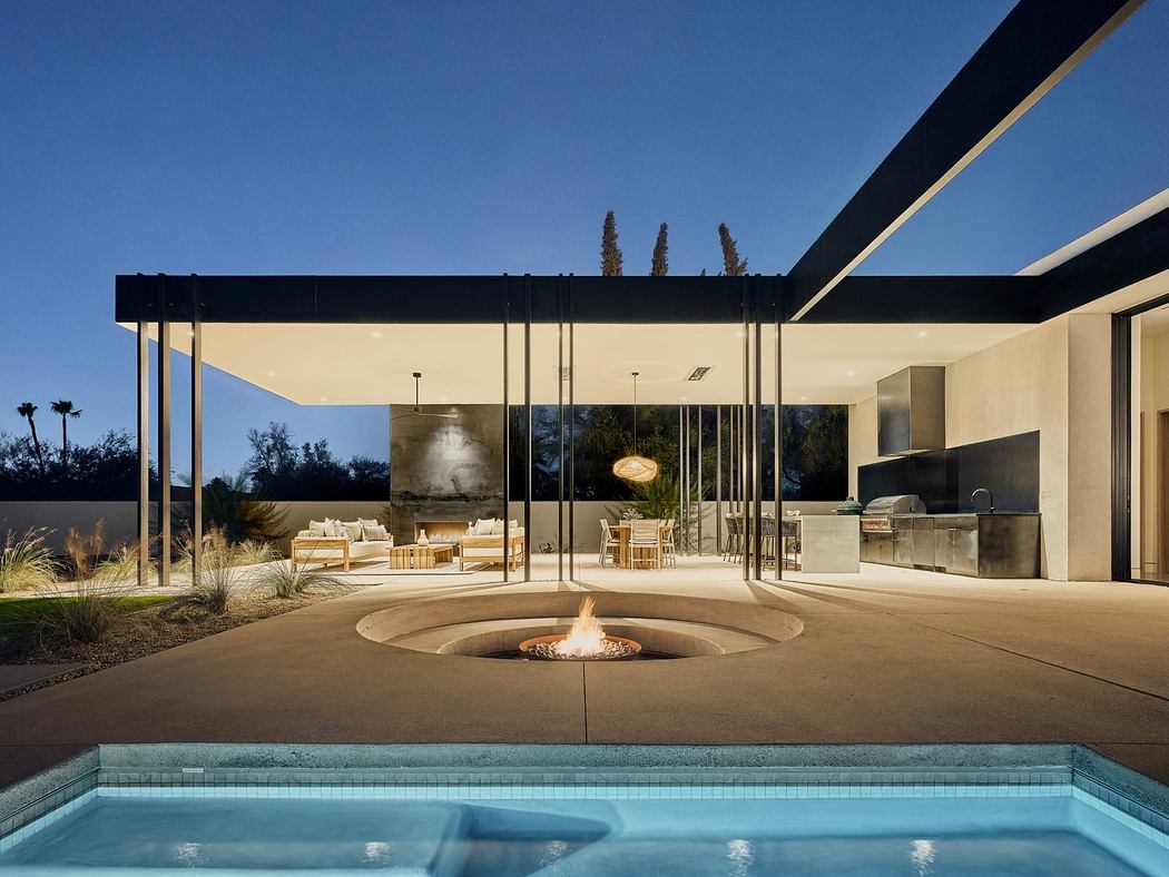 Modern patio with pool, fire pit, and open living space at dusk.