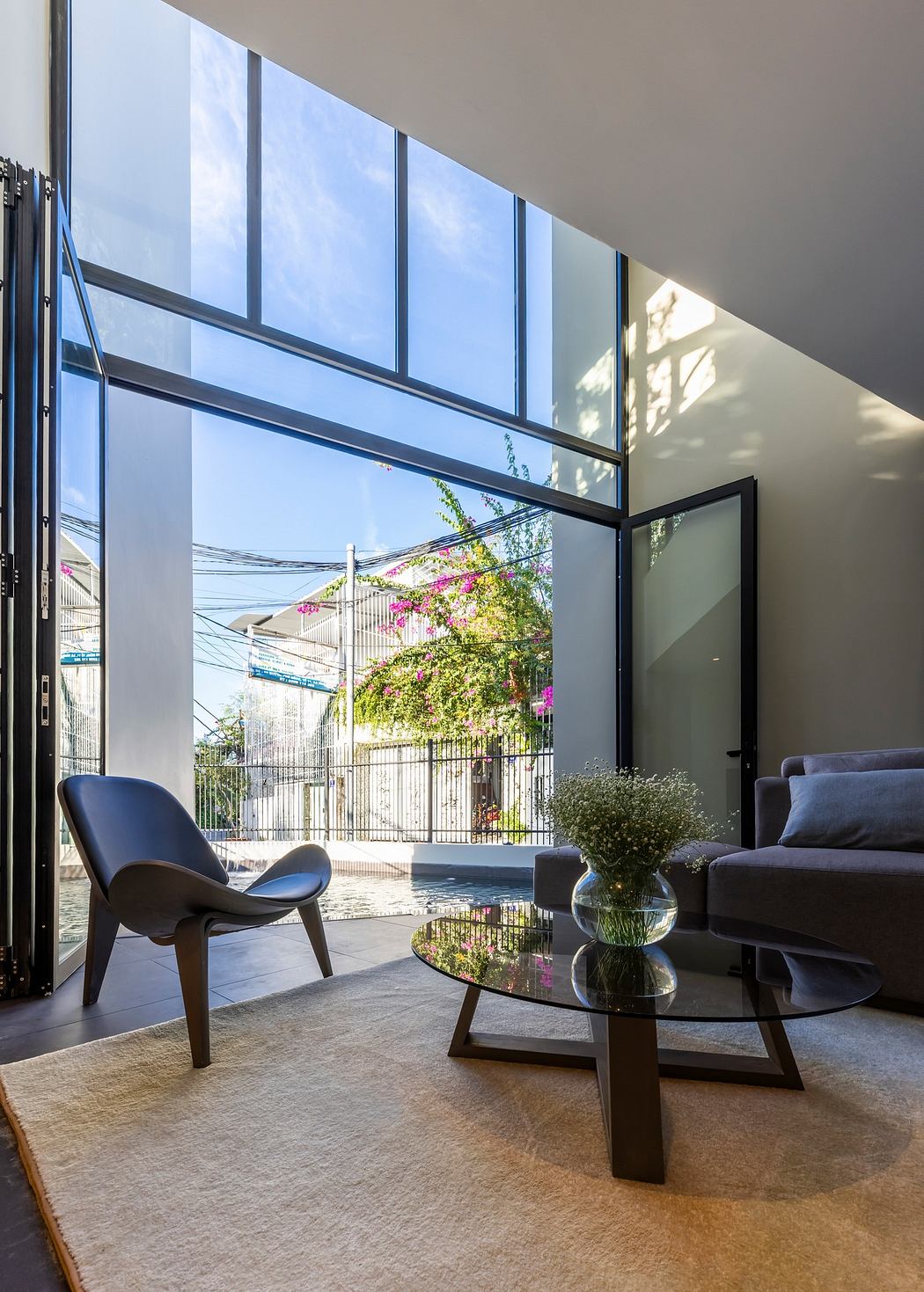 Modern living room with floor-to-ceiling windows and minimalist furniture.