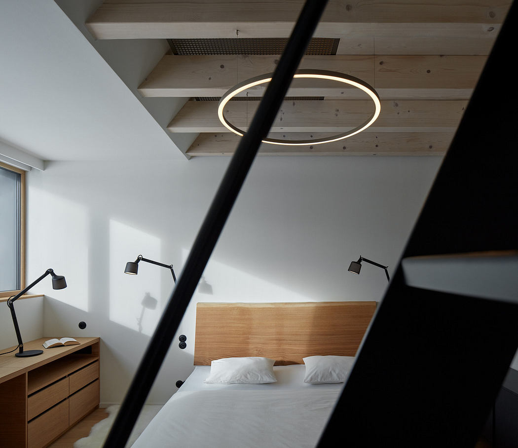 Modern bedroom with circular ceiling light and minimalist design.
