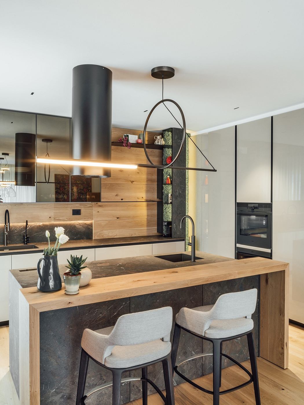 Modern kitchen with wood accents, island, and pendant lighting.