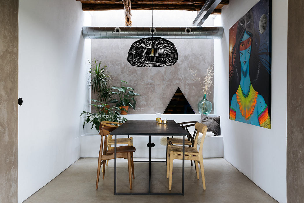 Modern dining room with artistic decor and pendant light.
