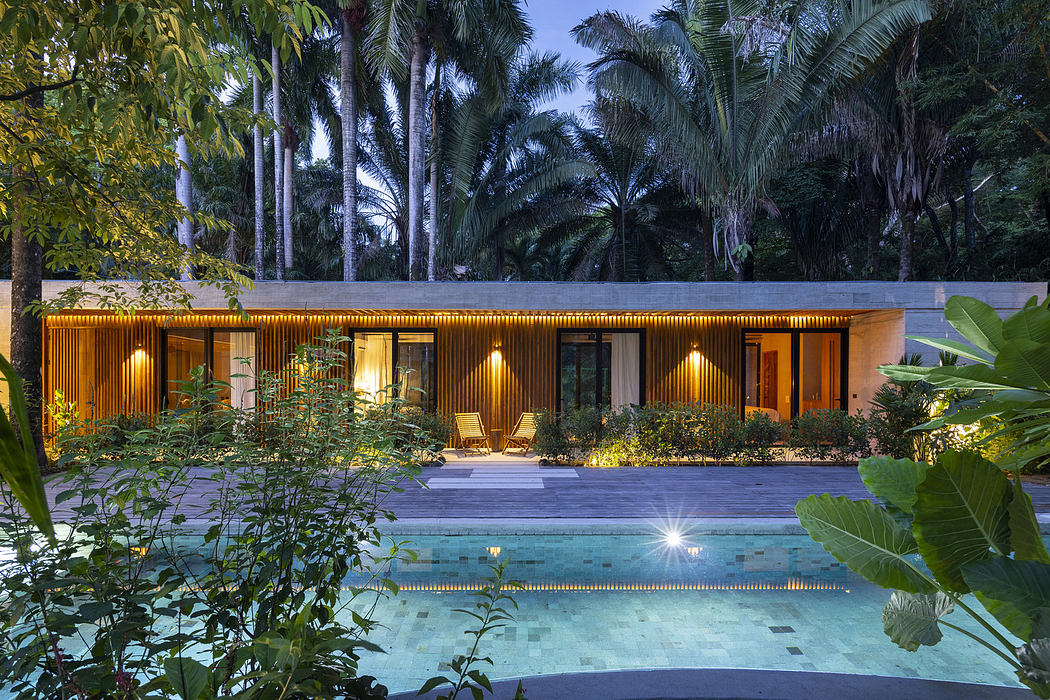 Modern house with pool surrounded by lush greenery at twilight.