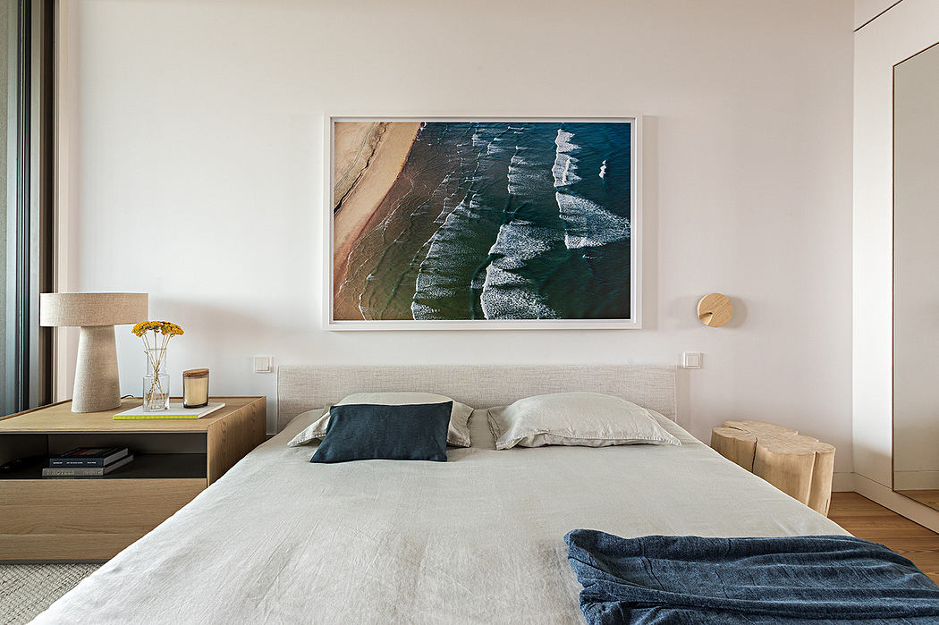 Minimalist bedroom with large abstract painting above the bed.