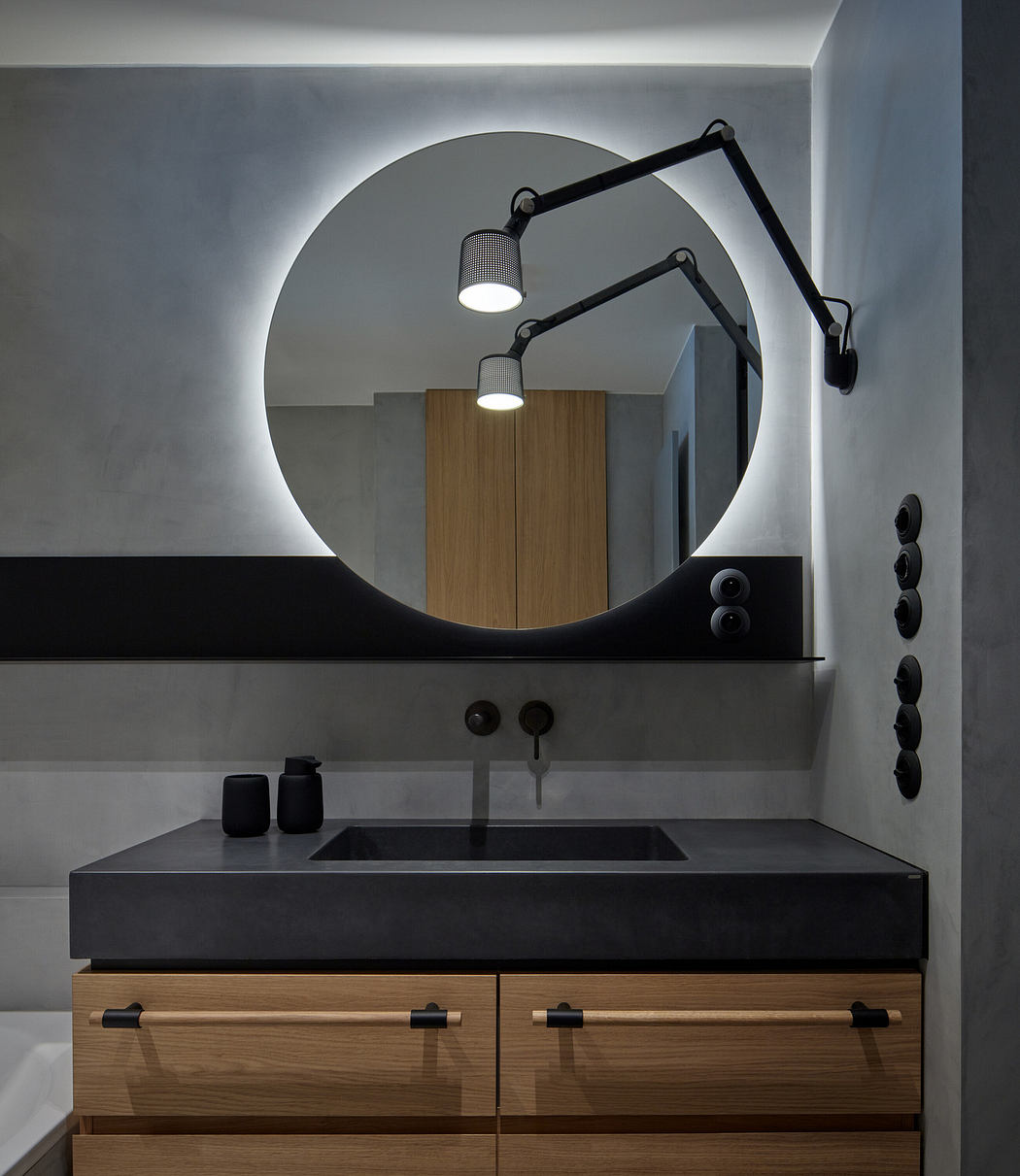Modern bathroom vanity with a circular mirror and adjustable wall lamp.