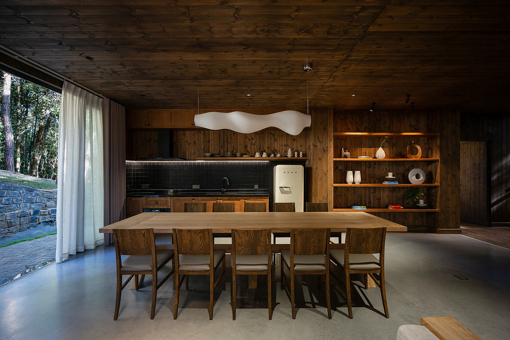 Modern kitchen with wood accents and large dining table.