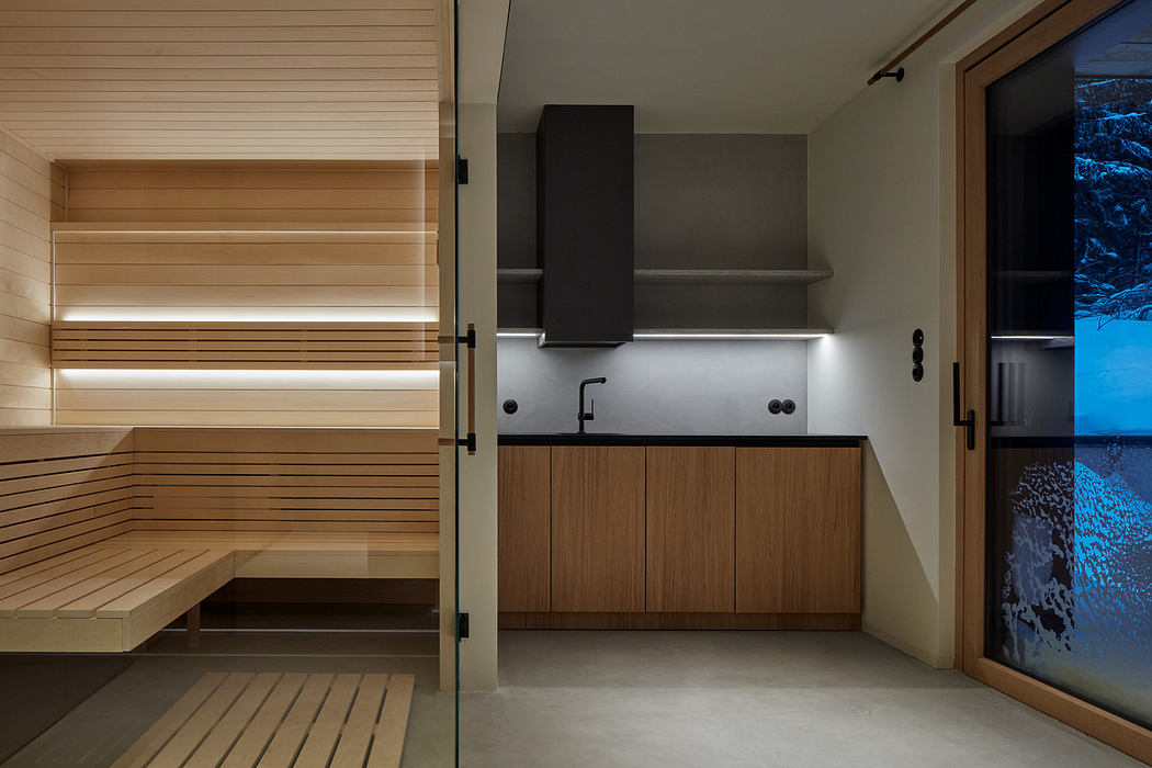 Modern home interior with integrated sauna and sleek kitchenette.