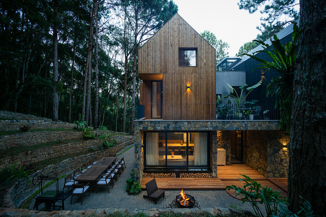 Modern wooden house with large windows nestled in a forest at dusk.
