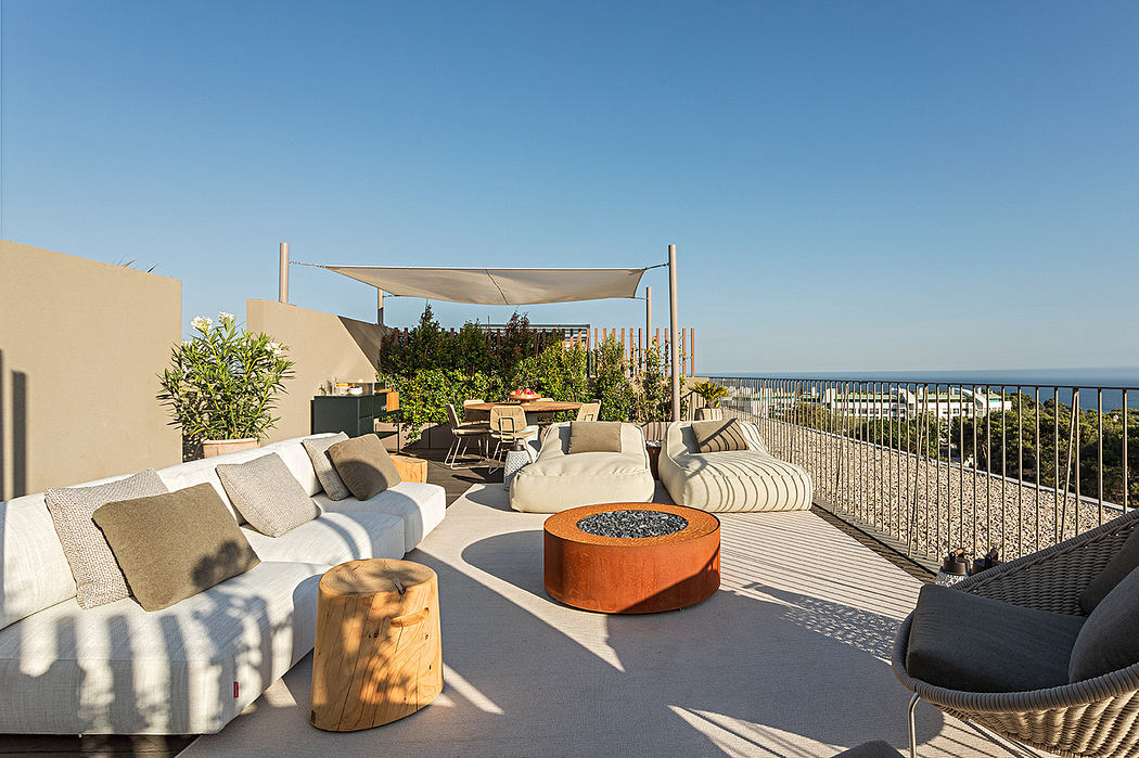 Modern rooftop terrace with ocean view, seating area, and fire pit.