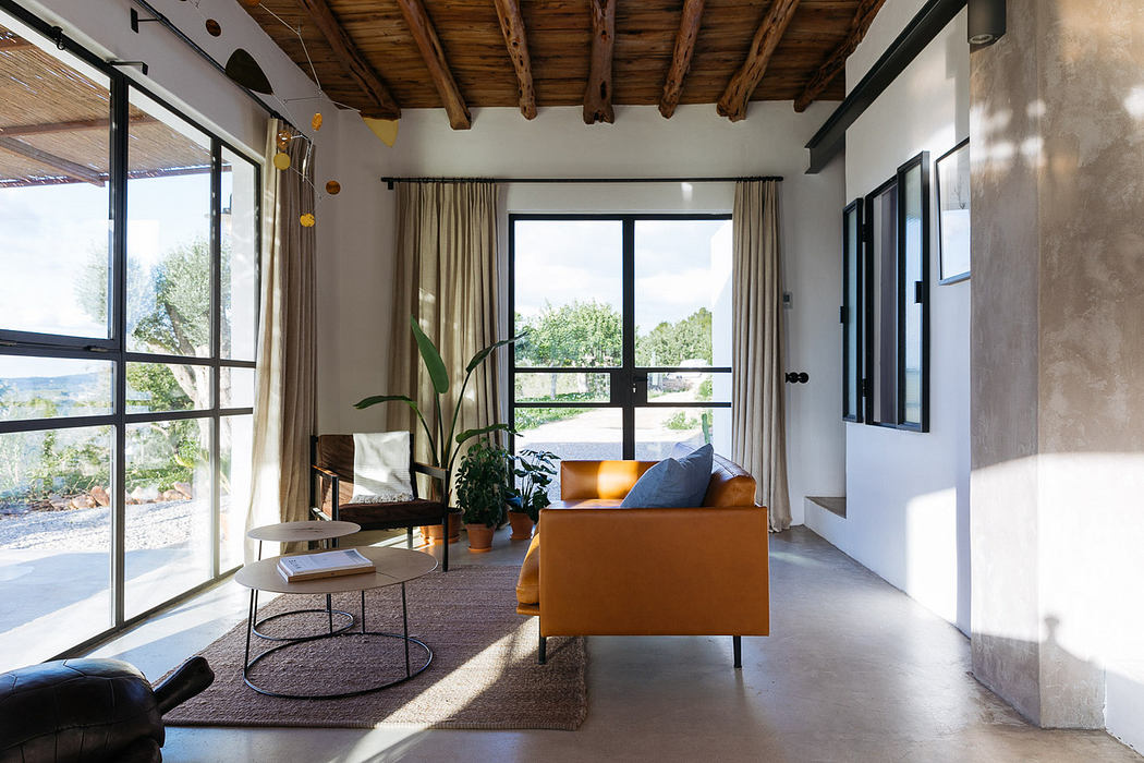 Modern living room with orange sofa, wood beams, and large windows.