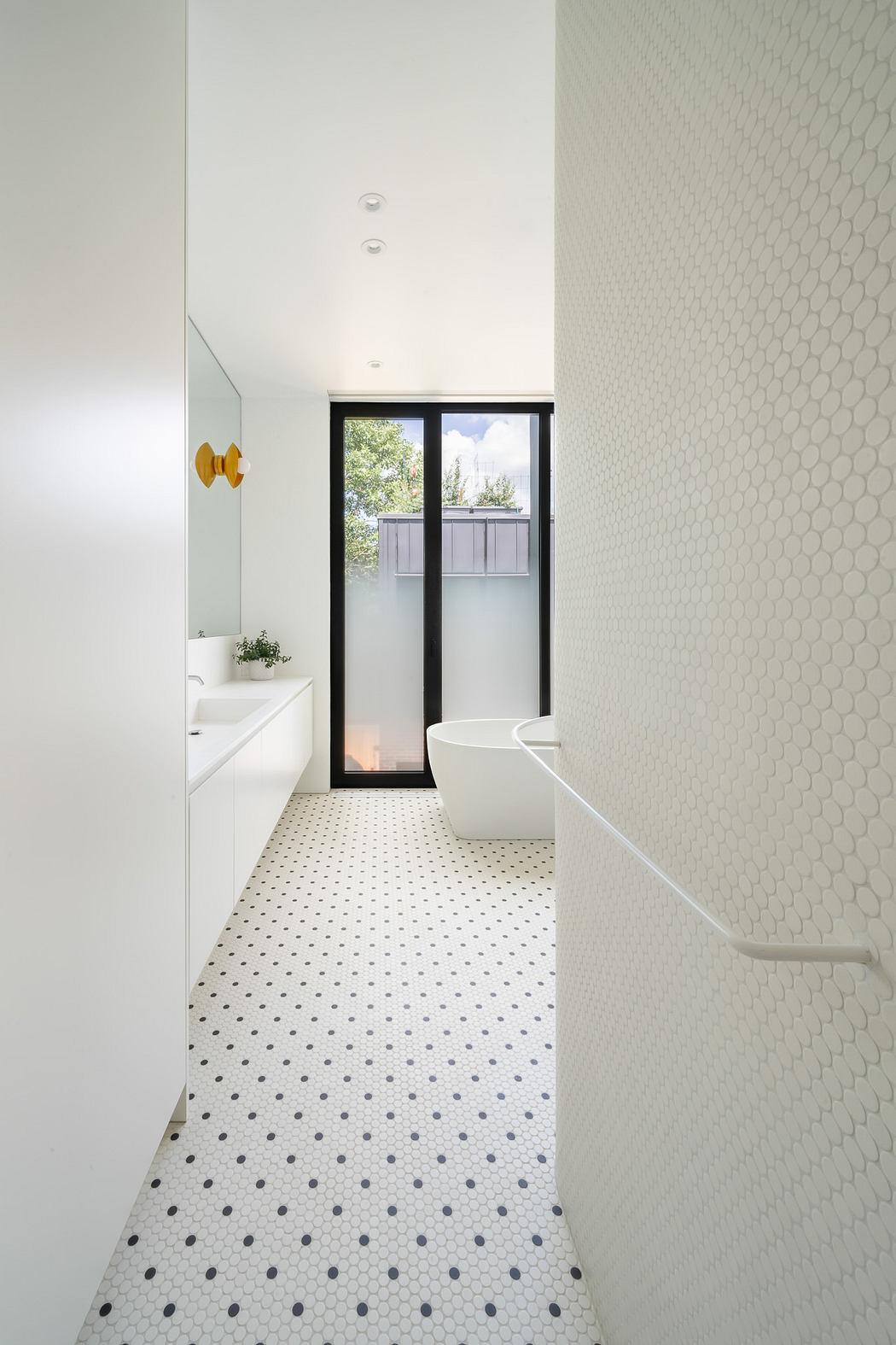 Modern bathroom with white hexagonal tiles and dotted floor.