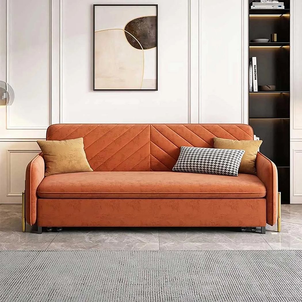 Modern living room with an orange sofa, abstract art, and sleek shelves.
