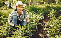Woman in a hat working in a garden