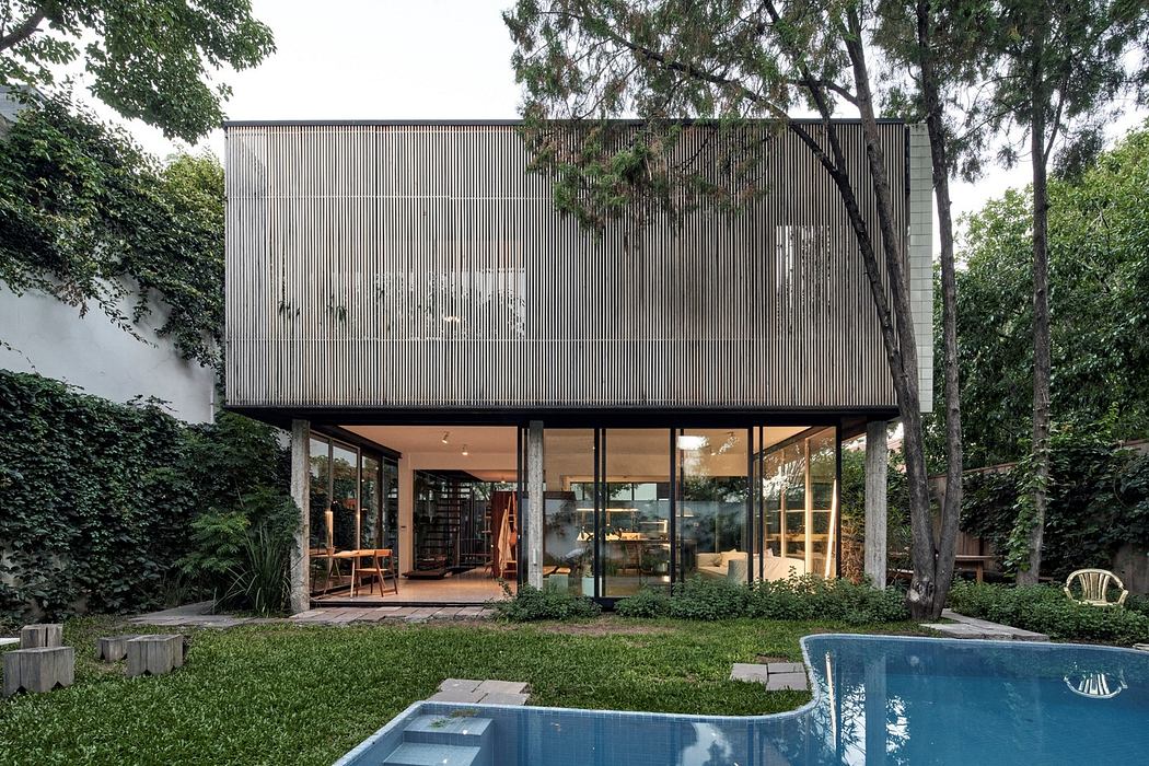 Contemporary two-story house with wooden slats over glass and pool.
