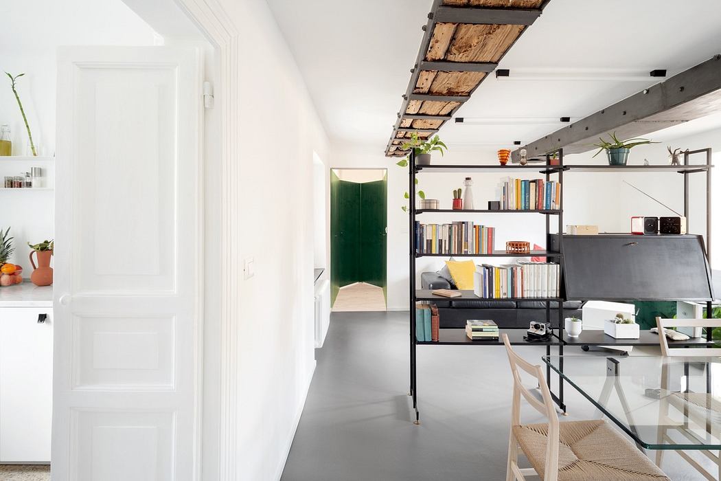 Contemporary interior with exposed beams, bookshelf, and minimalist decor.