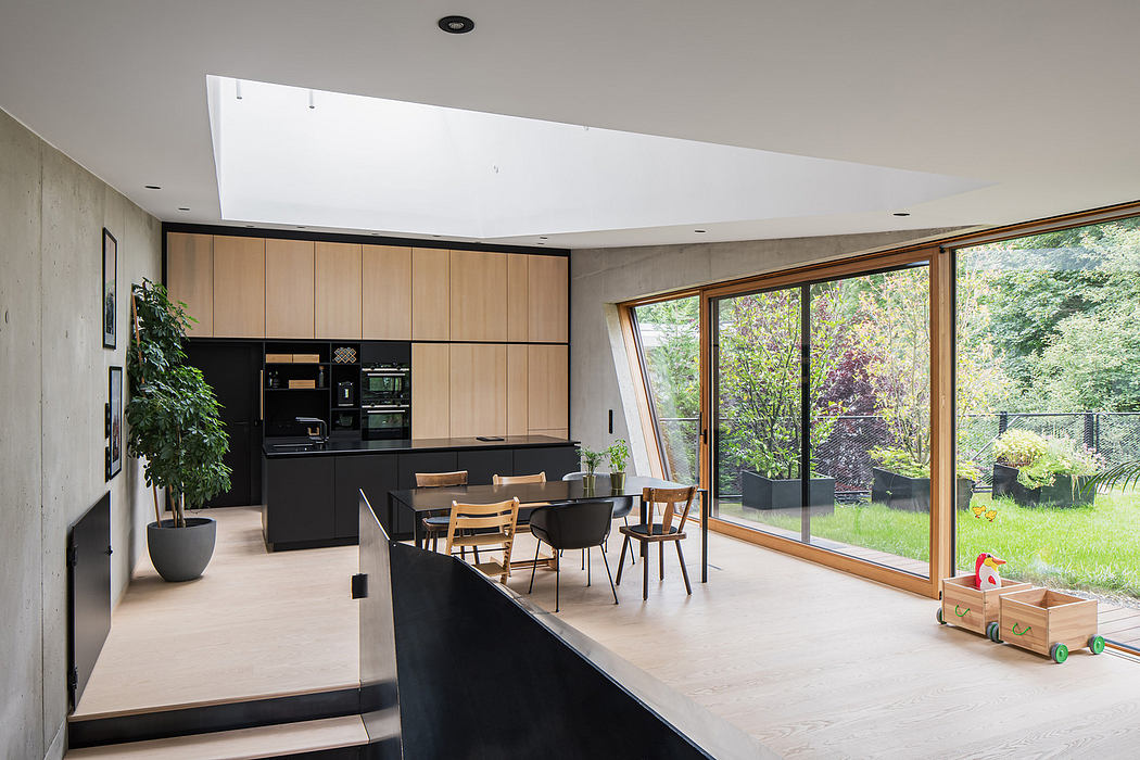 Modern kitchen with wood accents and dining area overlooking a garden.
