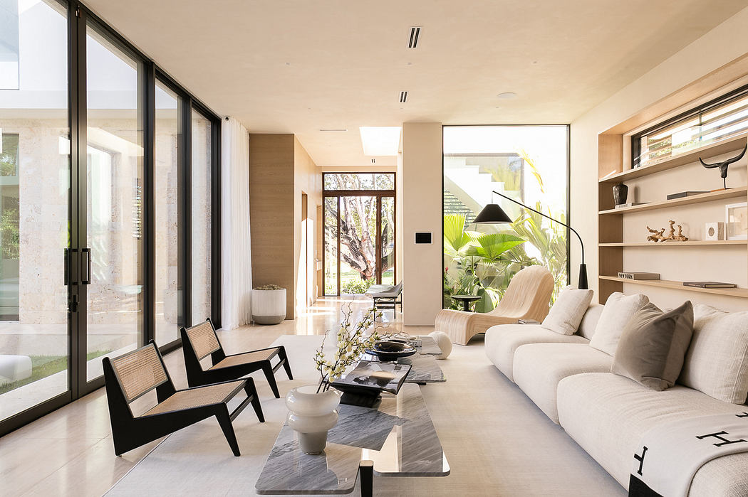 Modern living room with large windows, neutral tones, and minimalist decor.