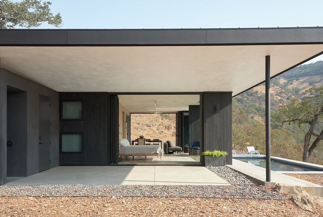 Modern house exterior with open patio and mountain view.