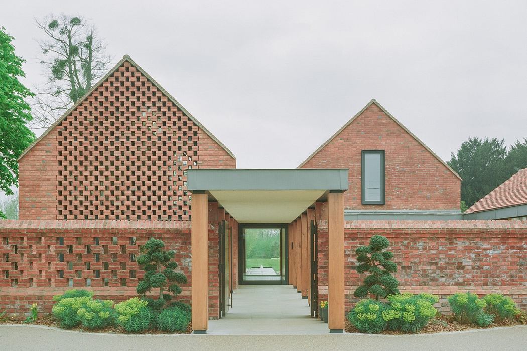 Modern brick buildings with a symmetrical walkway and landscaped greenery.