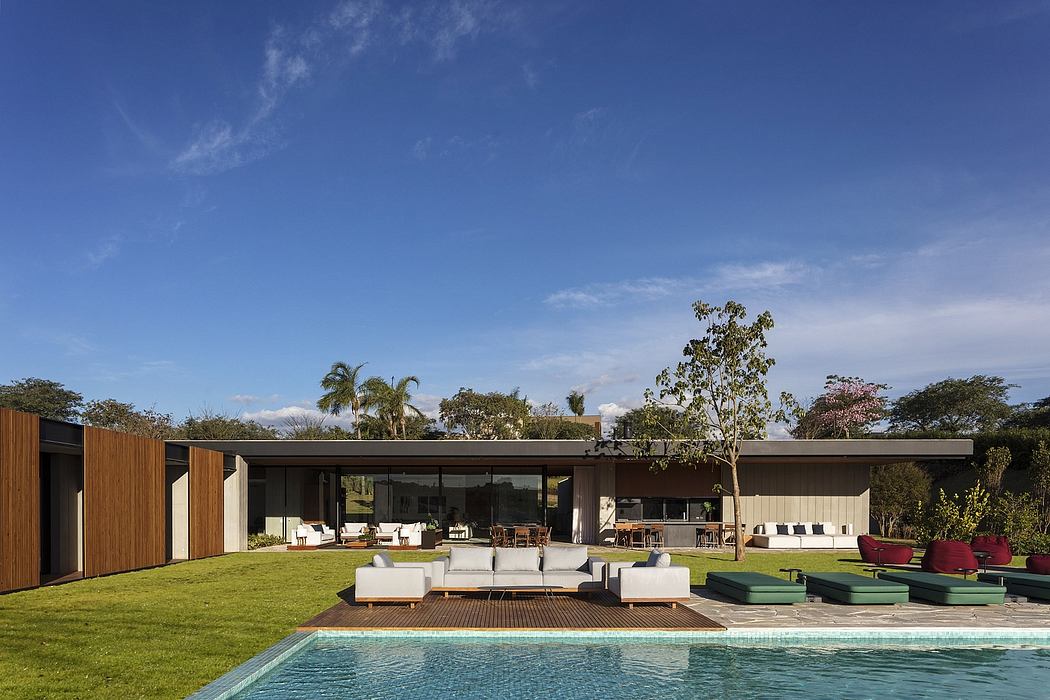 Contemporary house with expansive glass walls overlooking a pool.