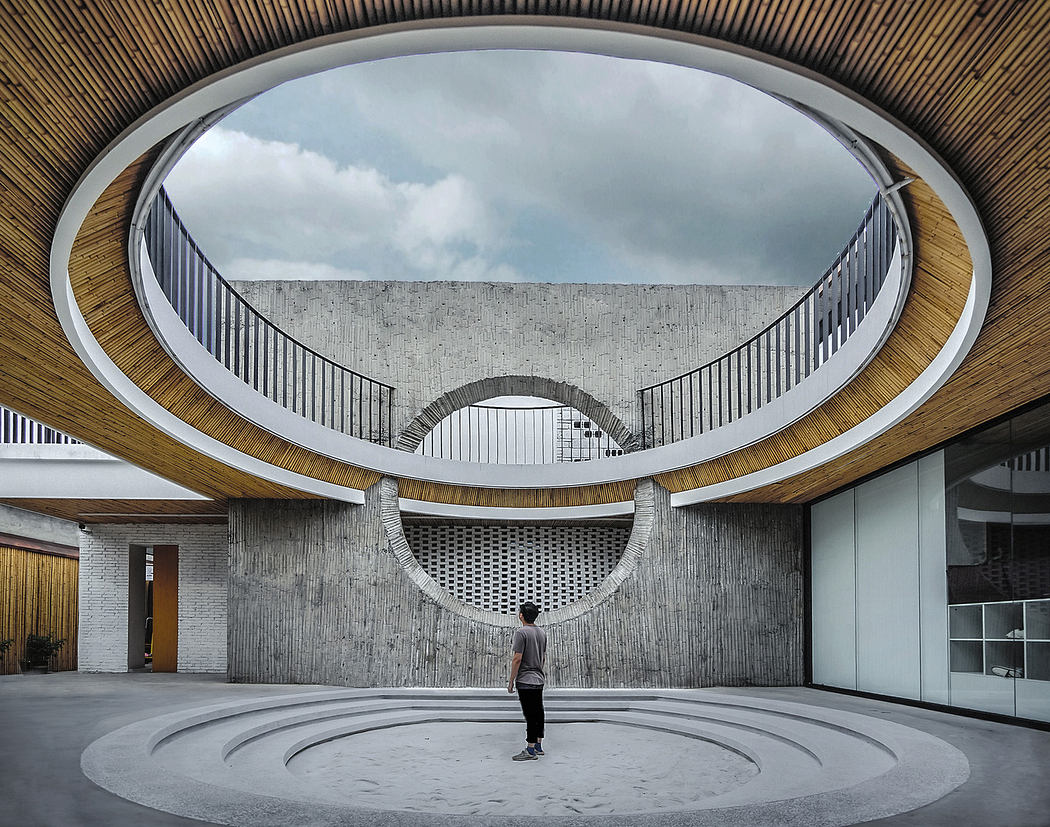 Modern interior courtyard with circular walkways and a person standing center.