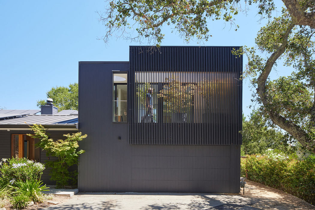 Modern house exterior with vertical slats and gray facade.