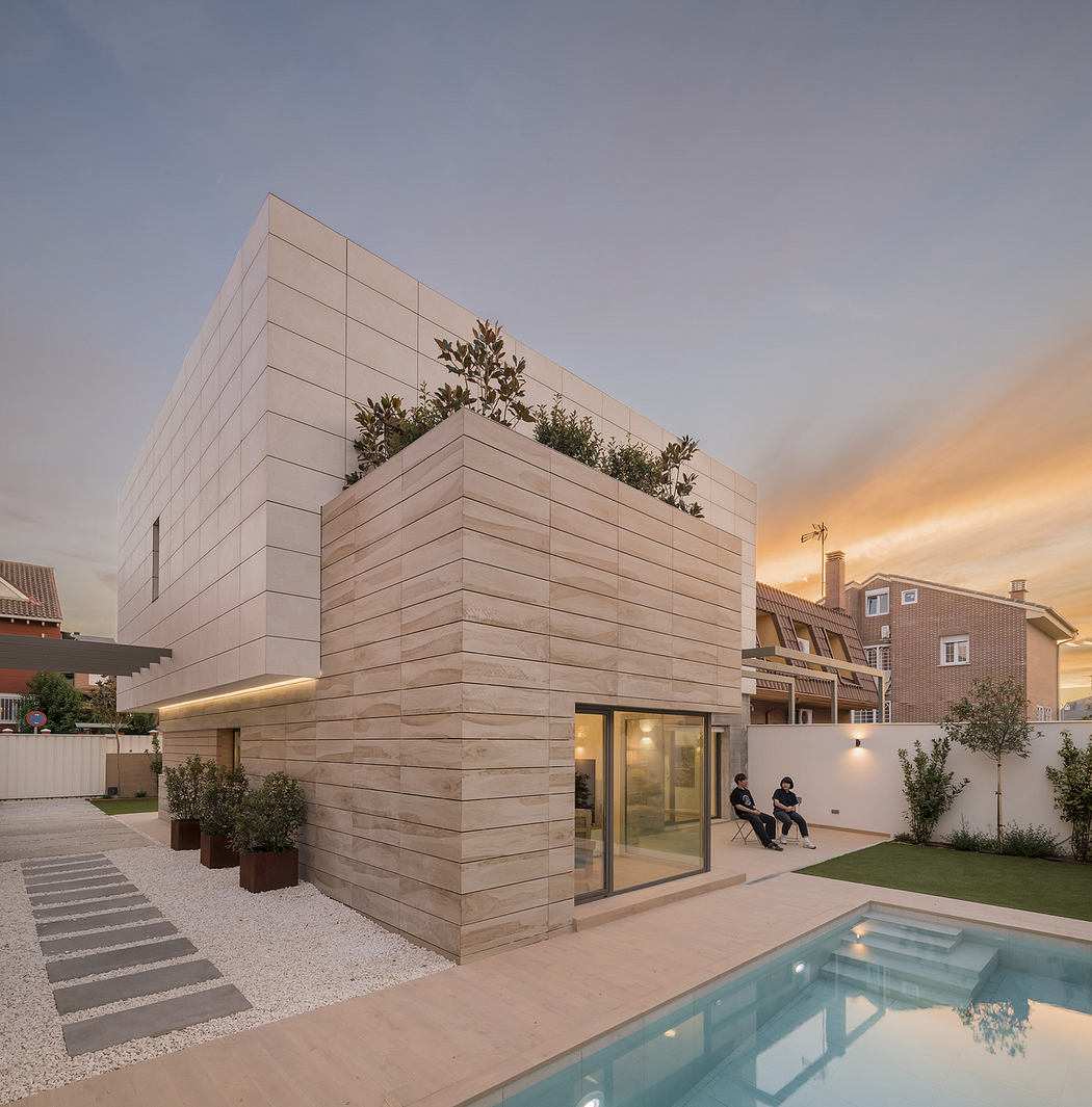 Contemporary two-story house with pool at dusk.