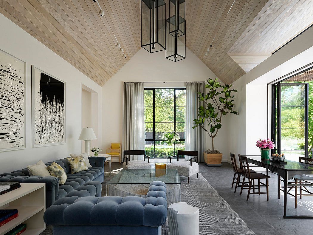 Stylish living room with vaulted ceiling, large windows, and chic furnishings