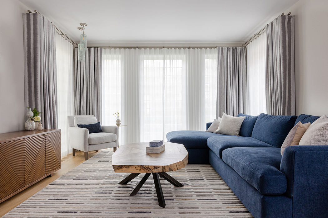 Contemporary living room with a blue sofa and wooden coffee table.