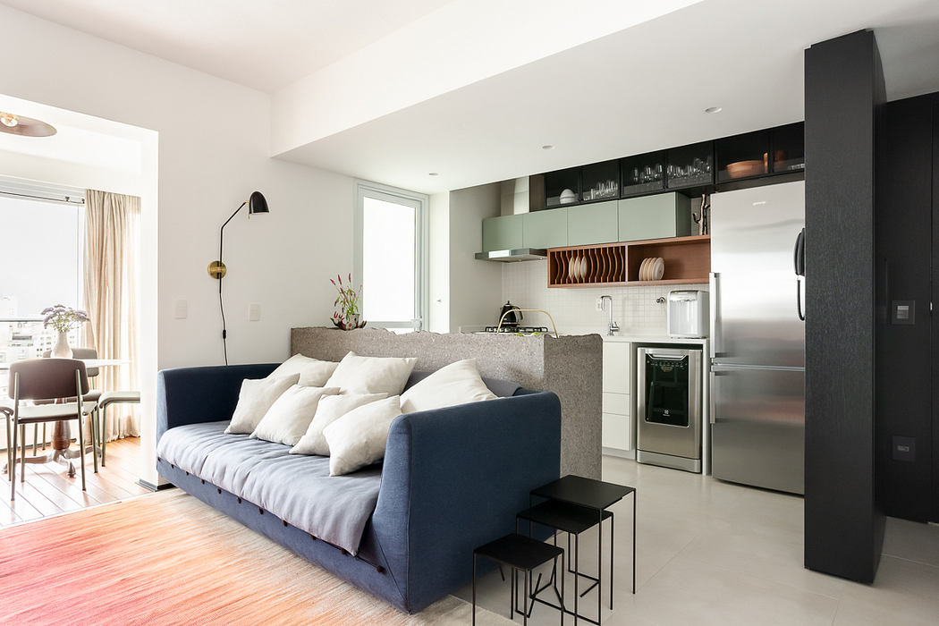 Sleek, open-plan living area with a blue sofa, integrated kitchen,