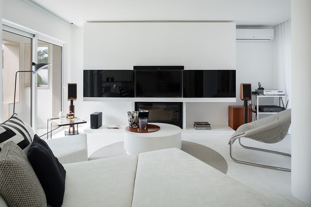 Minimalist living room with white decor and sleek furnishings.