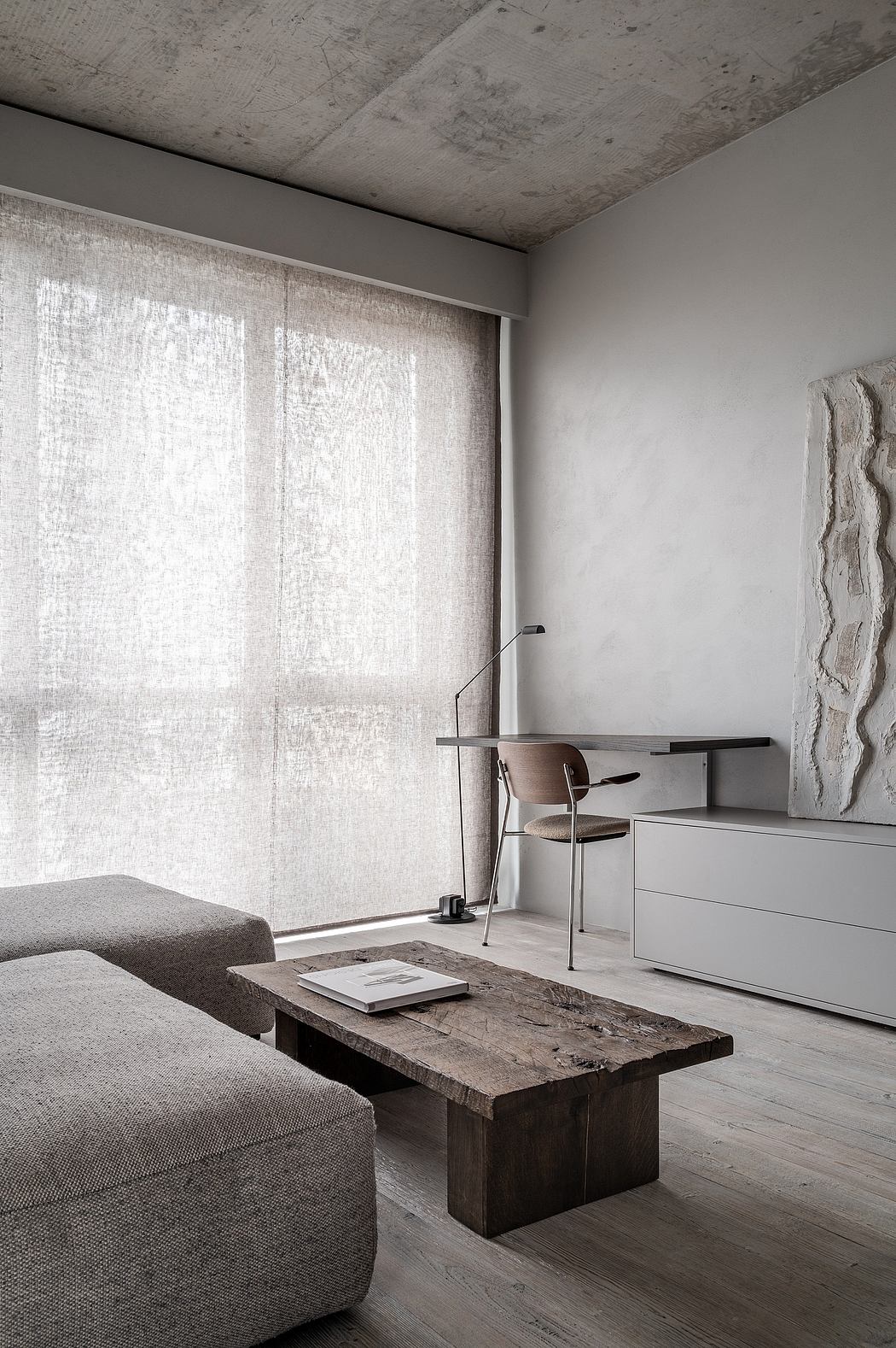 Minimalist living room with rustic wooden coffee table and sheer curtains.