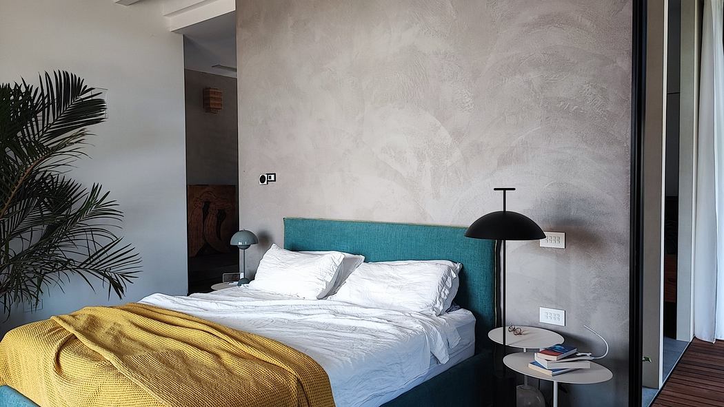 Contemporary bedroom with textured walls, teal headboard, and gold accents.