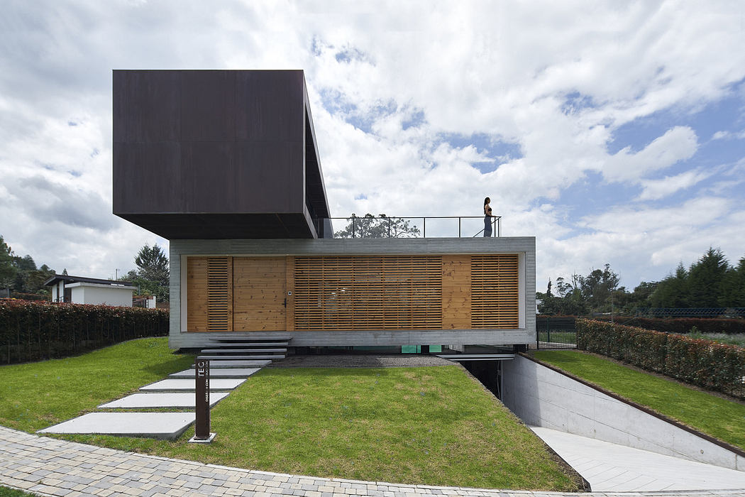 Modern house with cantilevered upper level and person on rooftop.