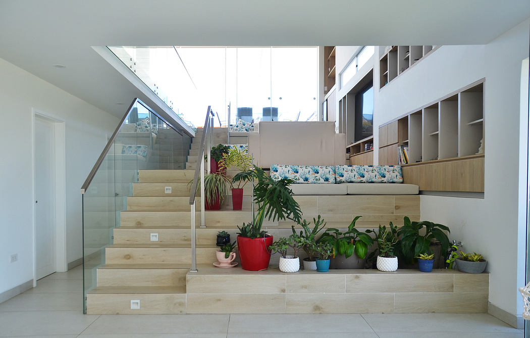 Bright indoor space featuring wooden stairs with integrated planters, a glass railing, and
