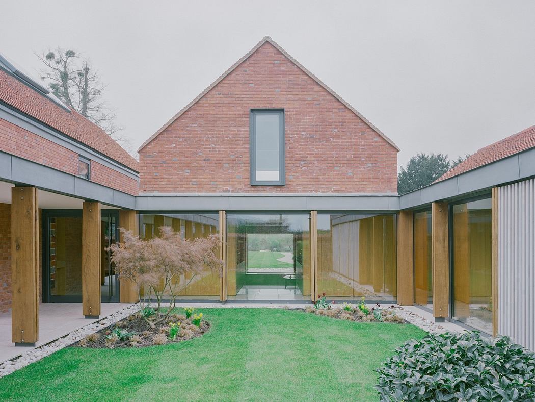 Modern brick house with glass corridor overlooking a courtyard garden.