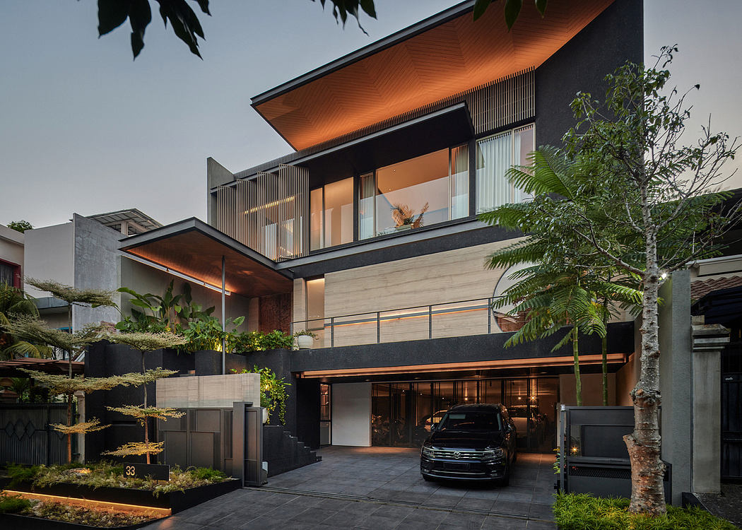 Modern two-story house with large windows and a car parked outside at dusk.