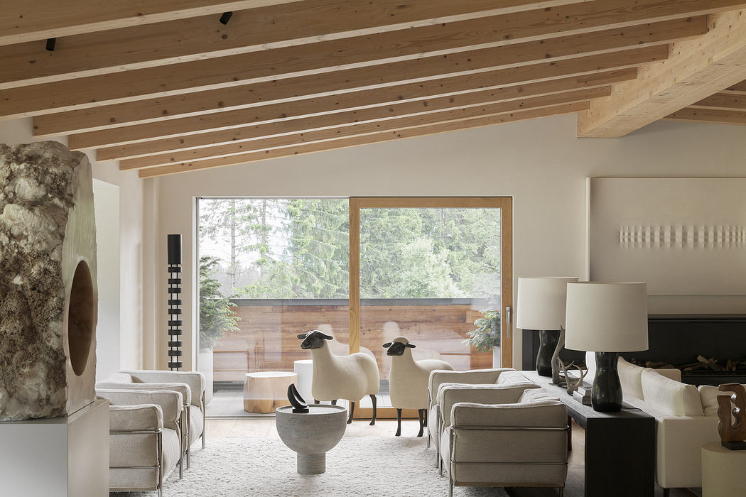 Modern living room with wooden beams, large windows, and neutral tones.