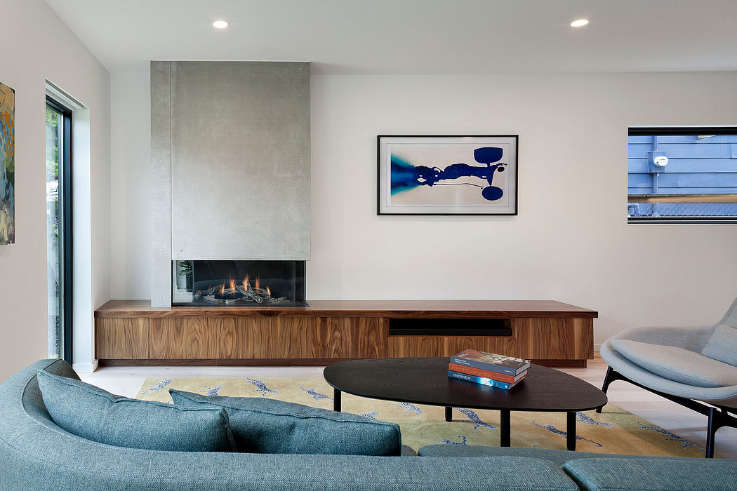 Modern living room with fireplace, blue sofa, and wall art.