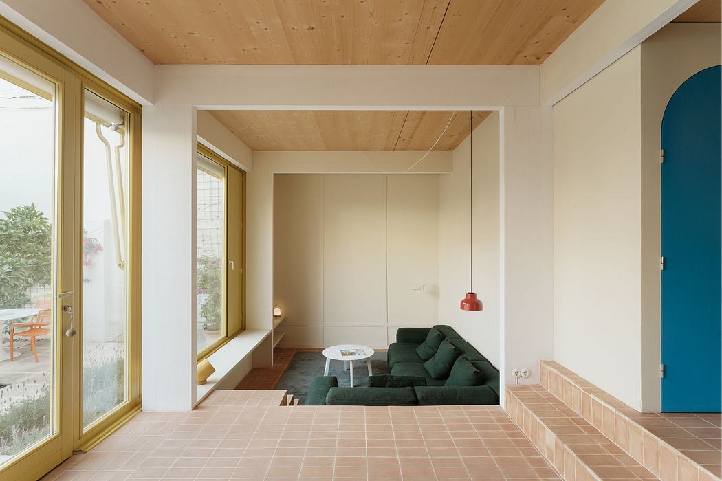 Modern minimalist living room with wooden ceiling and terracotta floor.