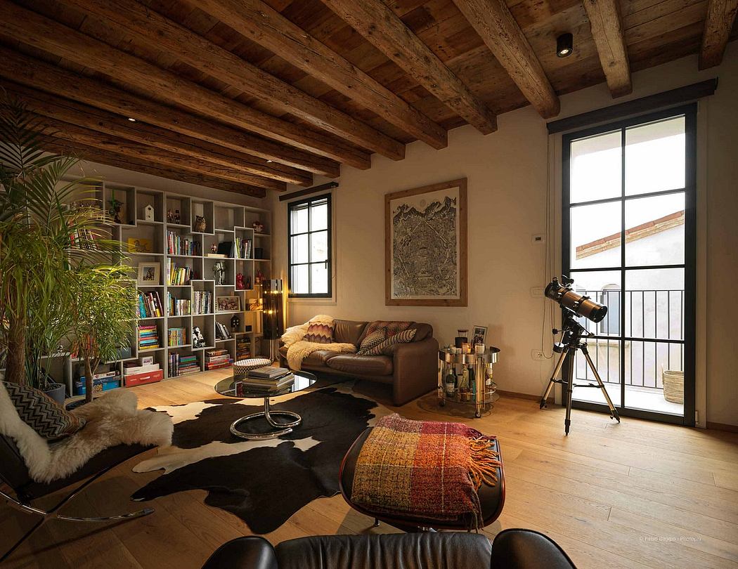 Cozy living room with exposed wood beams, bookshelves, and a telescope