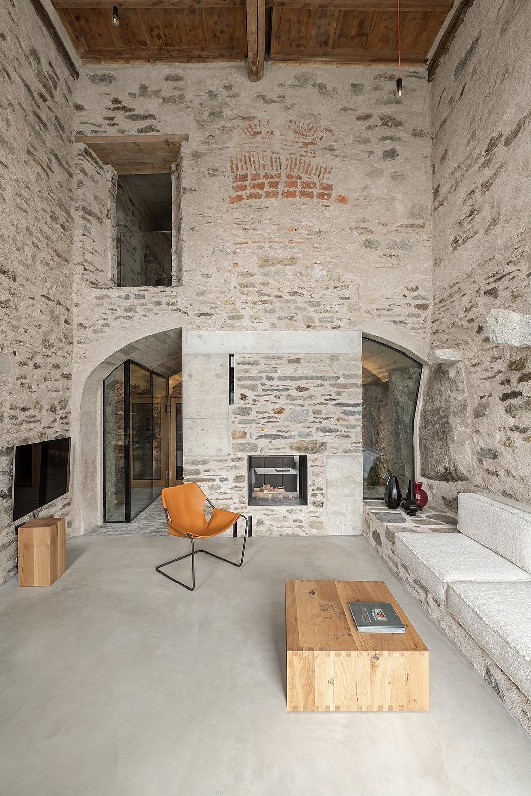 Contemporary room blending rustic stone walls with minimalist furniture.