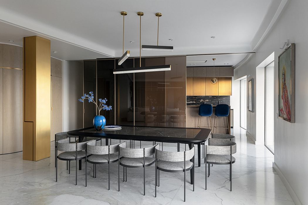 Modern dining room with a black table, grey chairs, pendant lights, and an