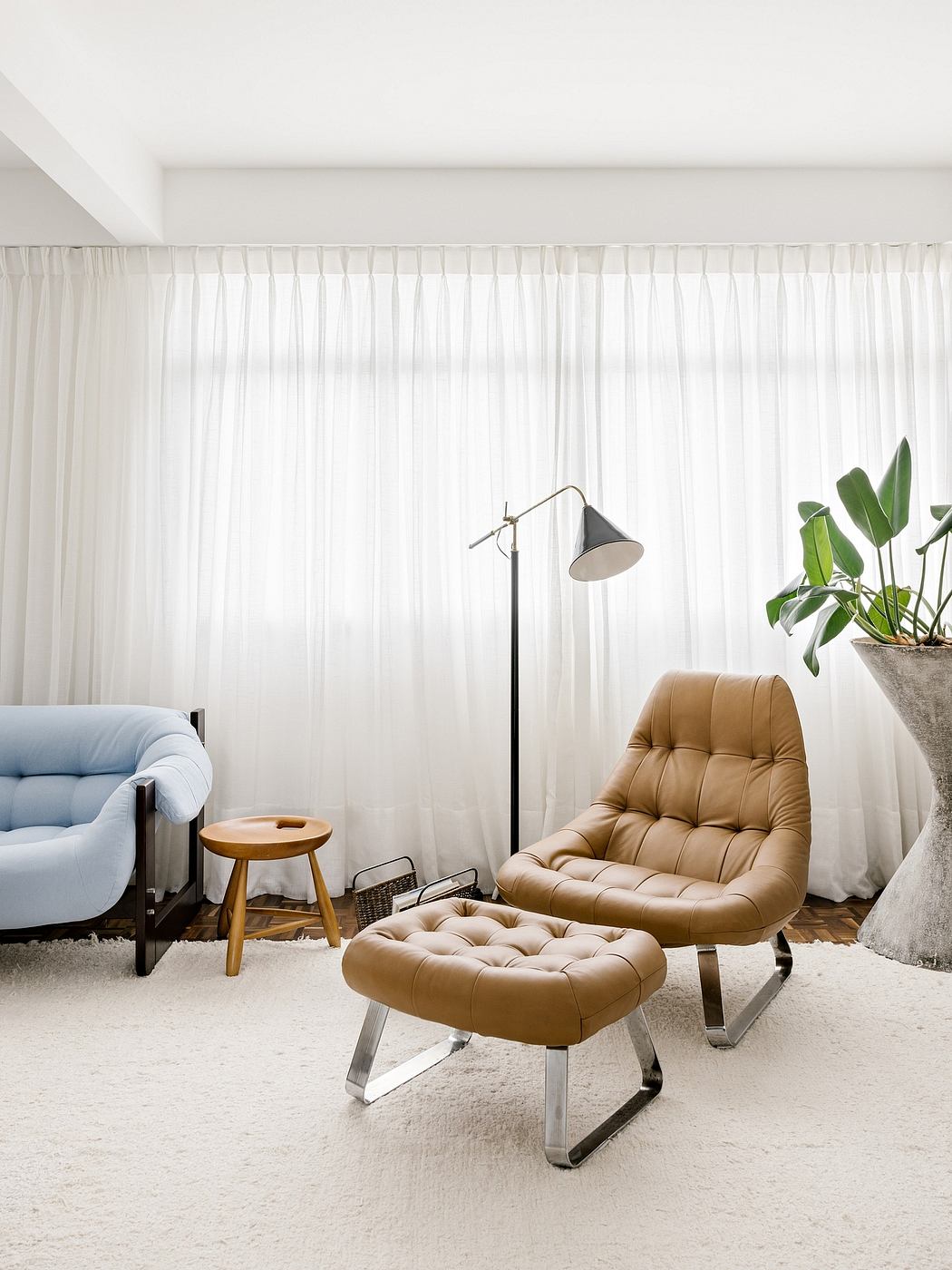 Modern room with a tan recliner, floor lamp, sheer curtains, and a