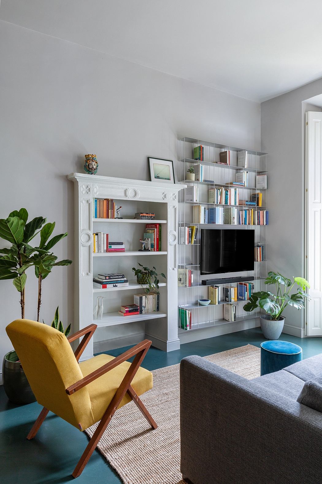 Contemporary living room with bookshelves and yellow armchair.