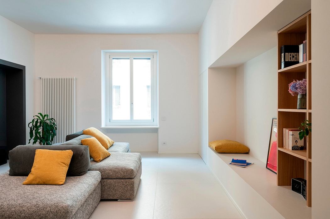 Modern living room with a grey sofa, white walls, and built-in shelves.