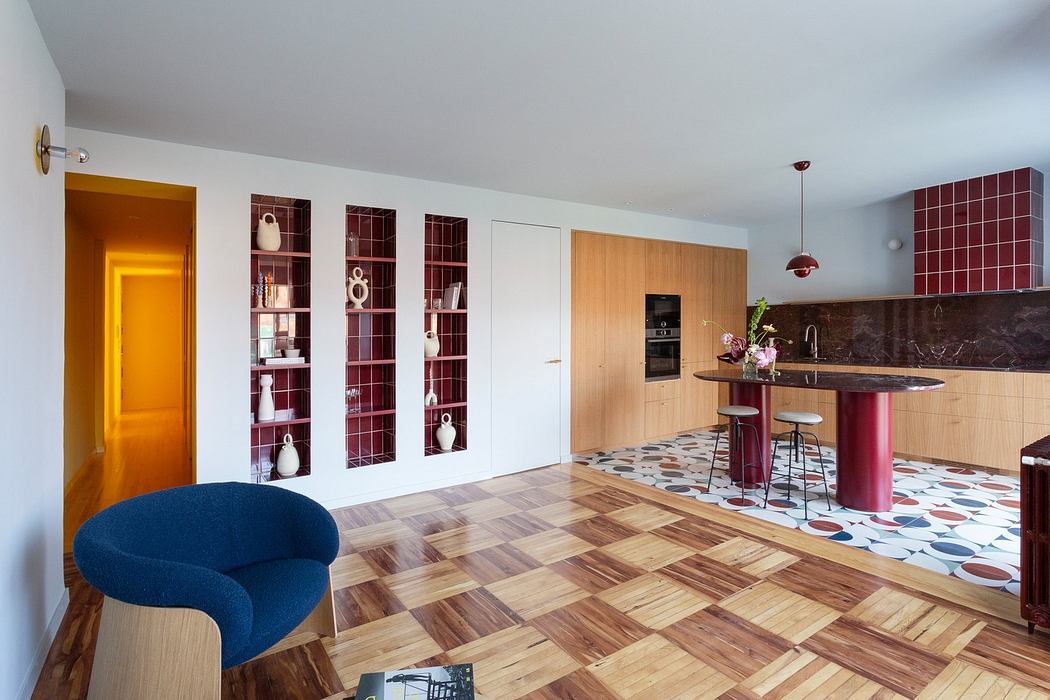 Modern kitchen with herringbone floor, patterned tiles, and burgundy island