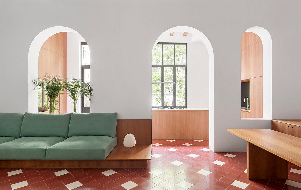 Minimalist room with arched windows, green sofa, and terracotta tiled