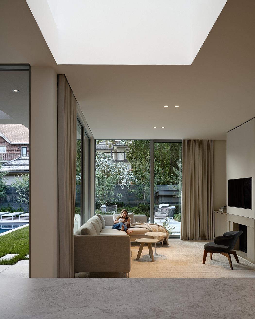 A modern living room with large windows, skylight, and a view of