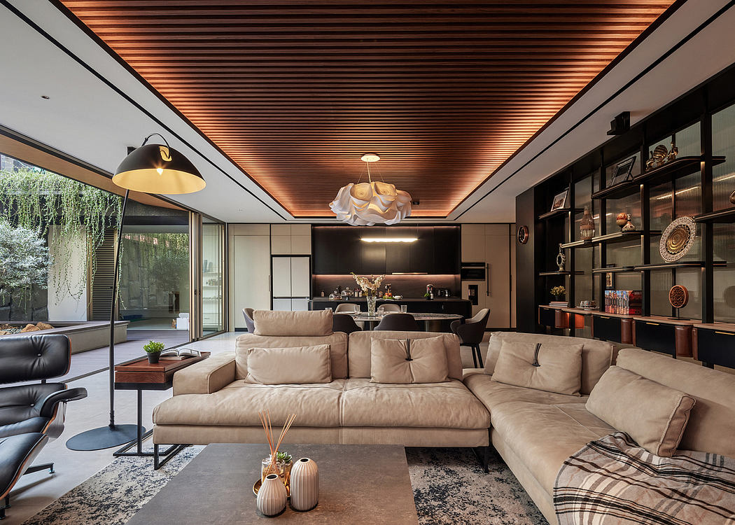 Modern living room with sectional sofa, wooden ceiling, and glass walls.
